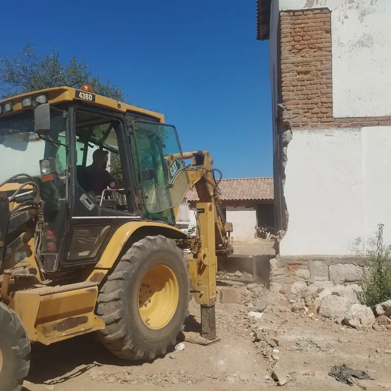 Excavadora CAT demoliendo un muro del molino